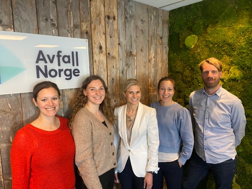 Ansatte til Avfall Norge som står foran en vegg med logoen til Avfall Norge